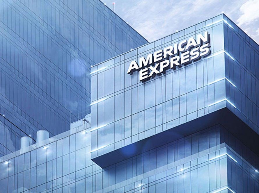 Illuminated dimensional letters reading American Express on a glass office tower