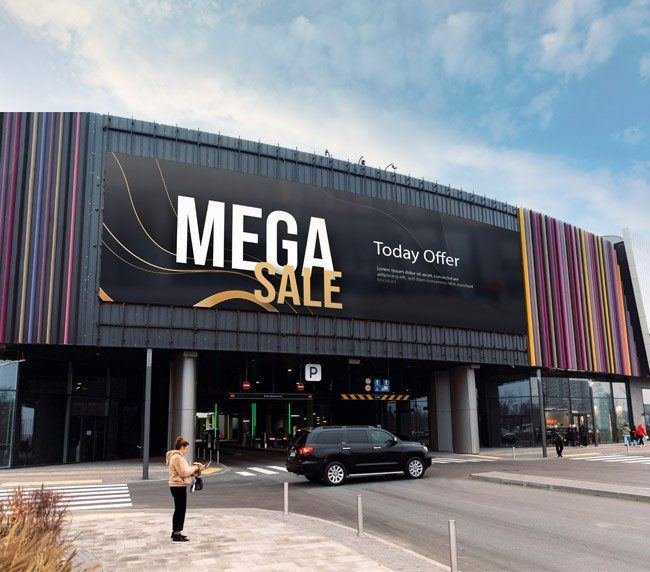 Large-format printed Mega Sale banner on a shopping centre facade above the parking entrance