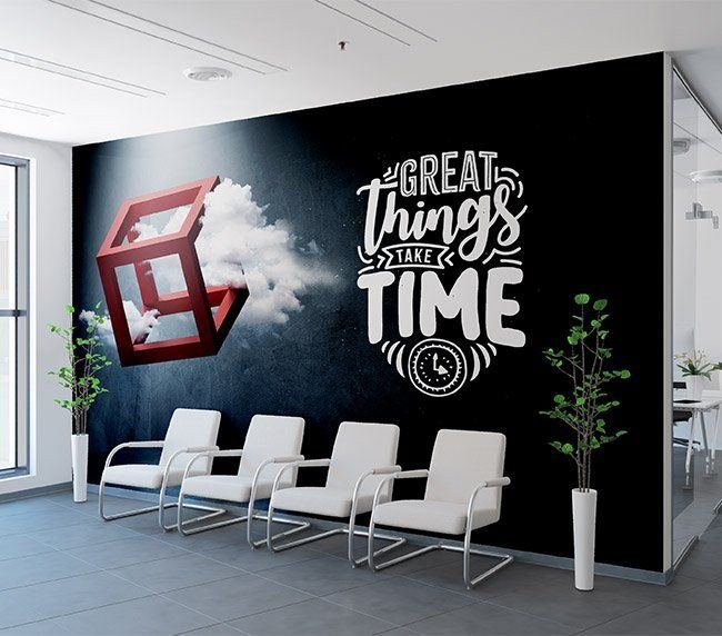 Black reception wall printed with a Great Things Take Time lettering graphic